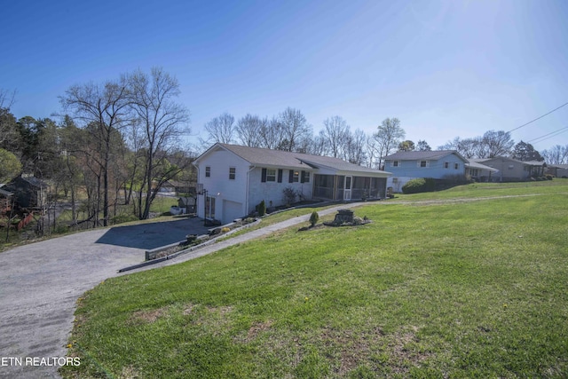 view of front of house featuring driveway, a garage, and a front yard