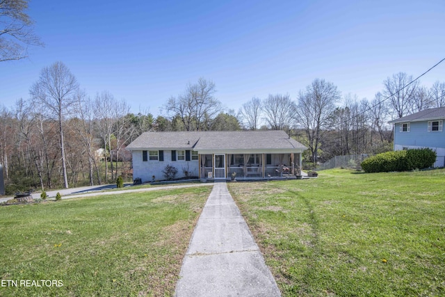 view of front facade with a front lawn and a sunroom