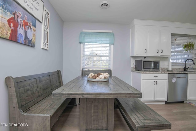 dining area featuring light wood-style flooring, visible vents, and breakfast area