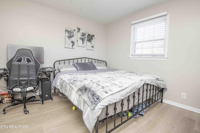 bedroom featuring baseboards and wood finished floors