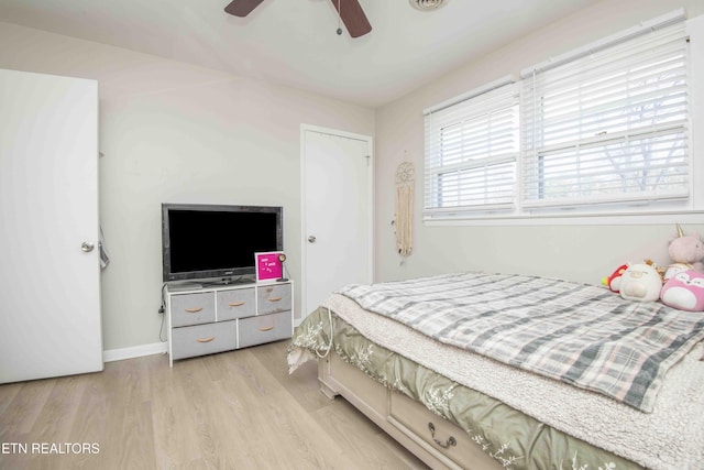 bedroom featuring a ceiling fan, baseboards, and wood finished floors