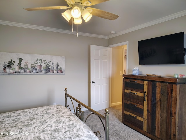 carpeted bedroom featuring baseboards, ornamental molding, and ceiling fan