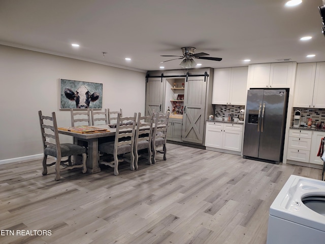 dining space featuring recessed lighting, light wood finished floors, a barn door, ceiling fan, and washer / clothes dryer