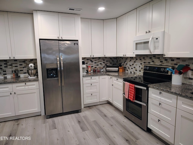 kitchen featuring tasteful backsplash, visible vents, appliances with stainless steel finishes, and white cabinetry