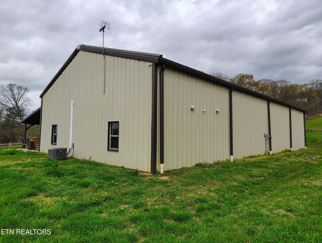 view of pole building featuring a yard and central AC