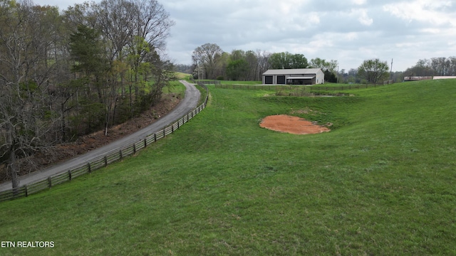 view of yard with fence and a rural view