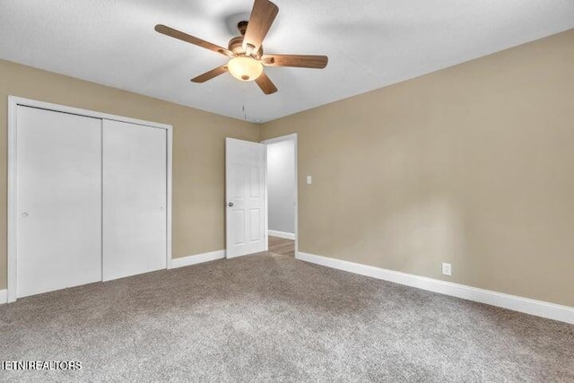 unfurnished bedroom with ceiling fan, a closet, carpet flooring, and baseboards