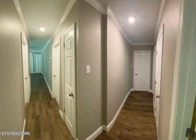 hallway featuring crown molding, baseboards, and dark wood finished floors