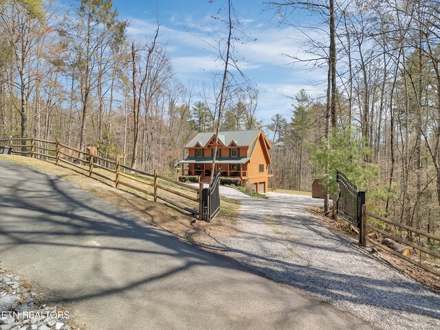 2164 Newt Huff Ln, Sevierville, TN 37862 - view of front of home featuring gravel driveway, a forest view, and fence