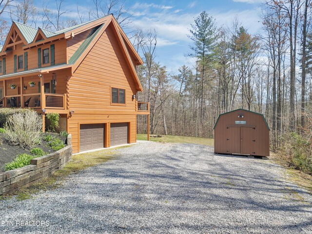 2164 Newt Huff Ln, Sevierville, TN 37862 - view of property exterior with an attached garage, a storage unit, gravel driveway, and an outbuilding