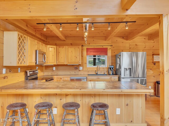 2164 Newt Huff Ln, Sevierville, TN 37862 - kitchen with light brown cabinets, wooden ceiling, wooden walls, and appliances with stainless steel finishes