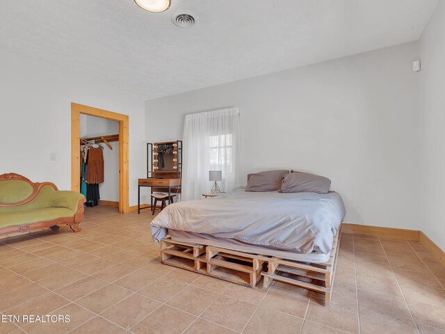 2164 Newt Huff Ln, Sevierville, TN 37862 - bedroom with a spacious closet, light tile patterned floors, baseboards, visible vents, and a closet
