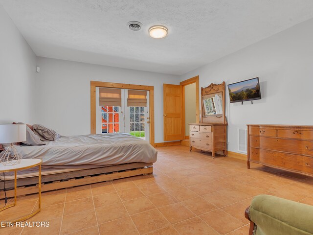 2164 Newt Huff Ln, Sevierville, TN 37862 - bedroom featuring access to outside, a textured ceiling, visible vents, and light tile patterned floors