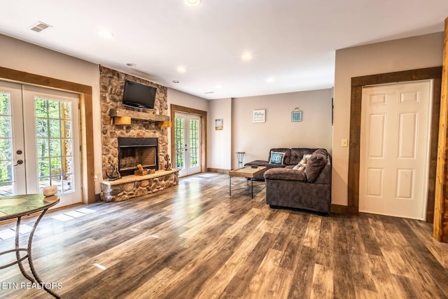 living area featuring wood finished floors, visible vents, a healthy amount of sunlight, and french doors