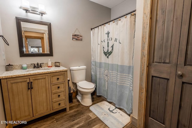 bathroom featuring wood finished floors, curtained shower, vanity, and toilet