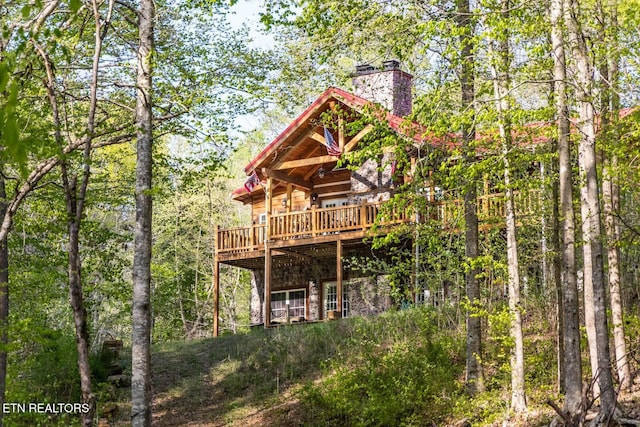 back of property featuring a wooden deck and a chimney