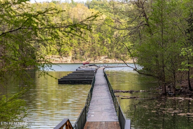 dock area with a wooded view and a water view
