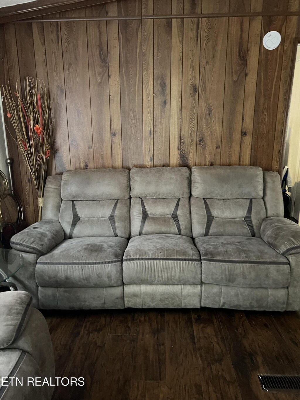 living room featuring dark wood-type flooring and wood walls