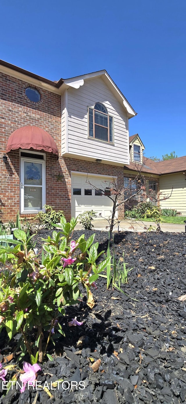 view of front of property with an attached garage and brick siding