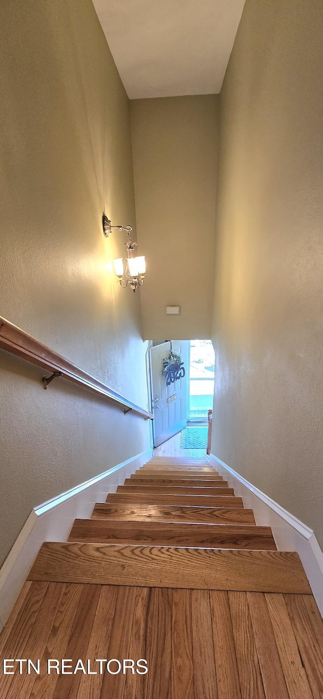 staircase with a textured wall and baseboards
