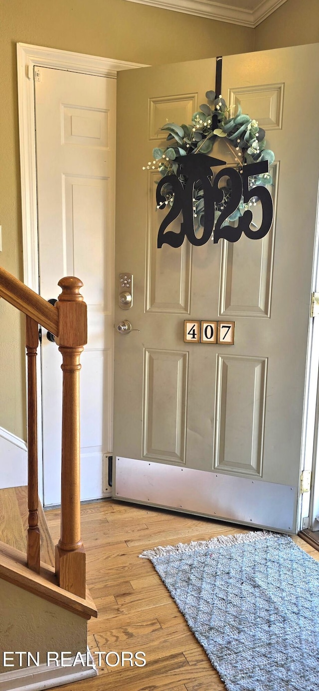 entrance foyer with wood finished floors and ornamental molding