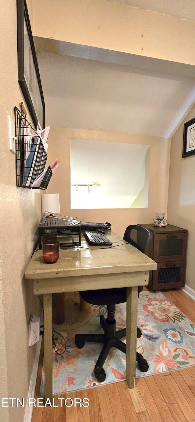 office featuring wood finished floors, baseboards, and lofted ceiling