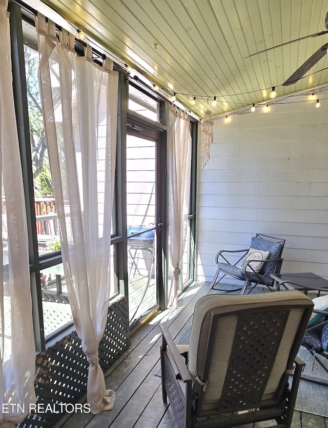 sunroom featuring track lighting and a healthy amount of sunlight