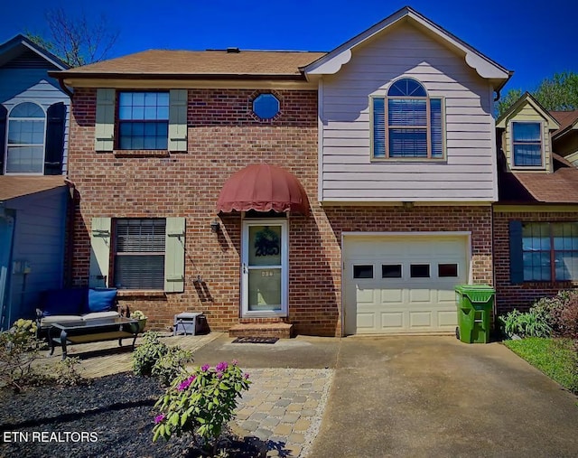 multi unit property with concrete driveway, brick siding, and a garage