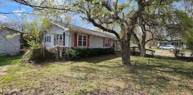 view of property exterior with fence and a lawn