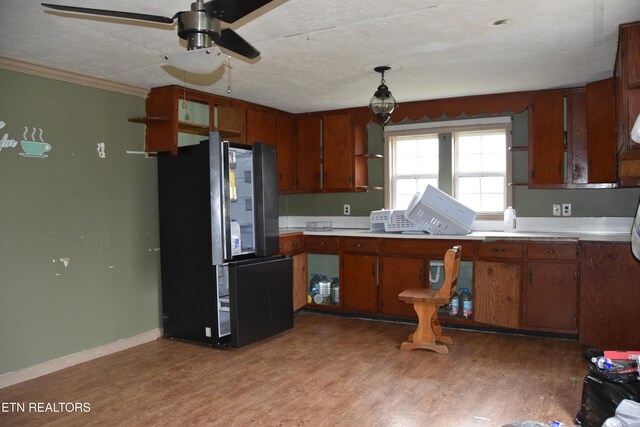 5128 Cove Creek Rd, Byrdstown, TN 38549 - kitchen featuring light countertops, light wood-style floors, brown cabinetry, and freestanding refrigerator