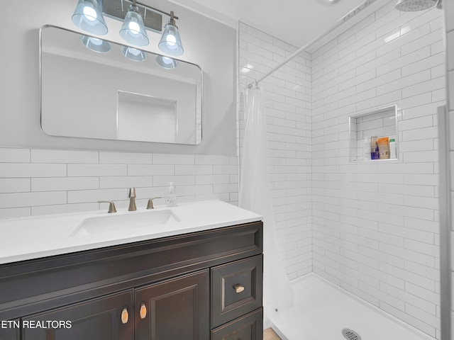 bathroom with a shower stall, tile walls, tasteful backsplash, and vanity