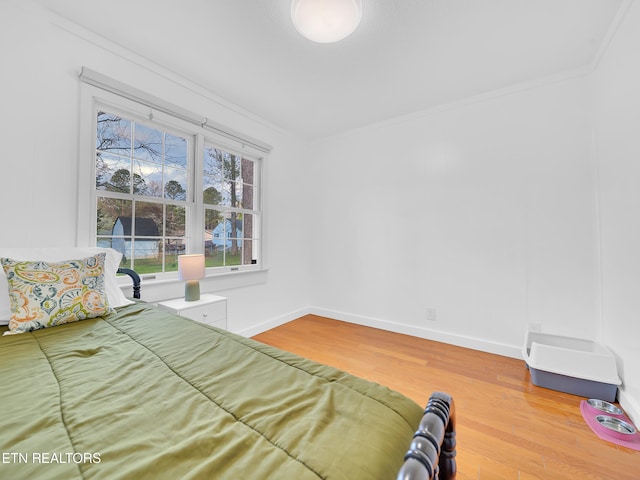 unfurnished bedroom featuring baseboards, wood finished floors, and ornamental molding