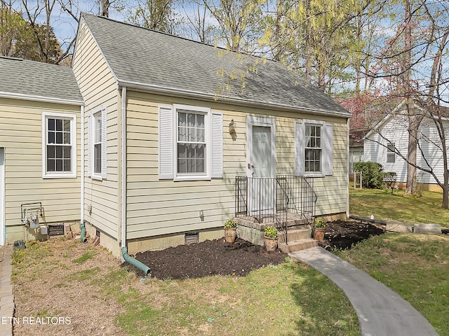 view of front facade with a front lawn, crawl space, and a shingled roof