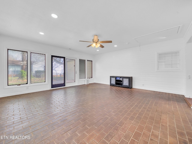 unfurnished living room featuring brick floor, ceiling fan, recessed lighting, and attic access