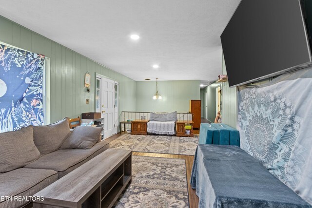 living room with wood finished floors and a notable chandelier