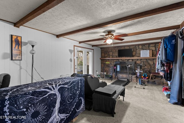 bedroom with access to exterior, carpet, beamed ceiling, and a textured ceiling