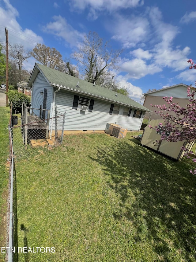 rear view of house featuring fence and a yard