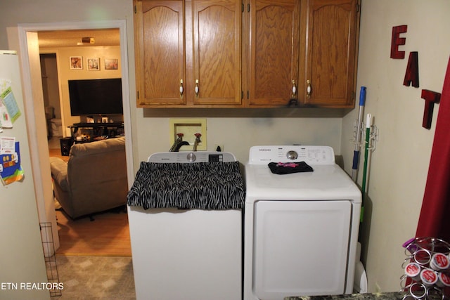 clothes washing area with cabinet space and washer / dryer