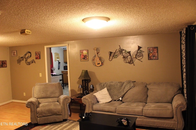 living area featuring baseboards, a textured ceiling, and wood finished floors