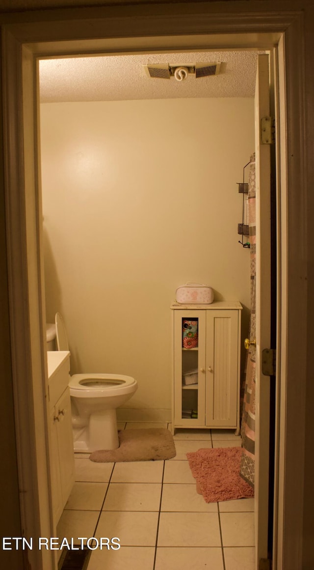 bathroom featuring tile patterned flooring, vanity, toilet, and visible vents