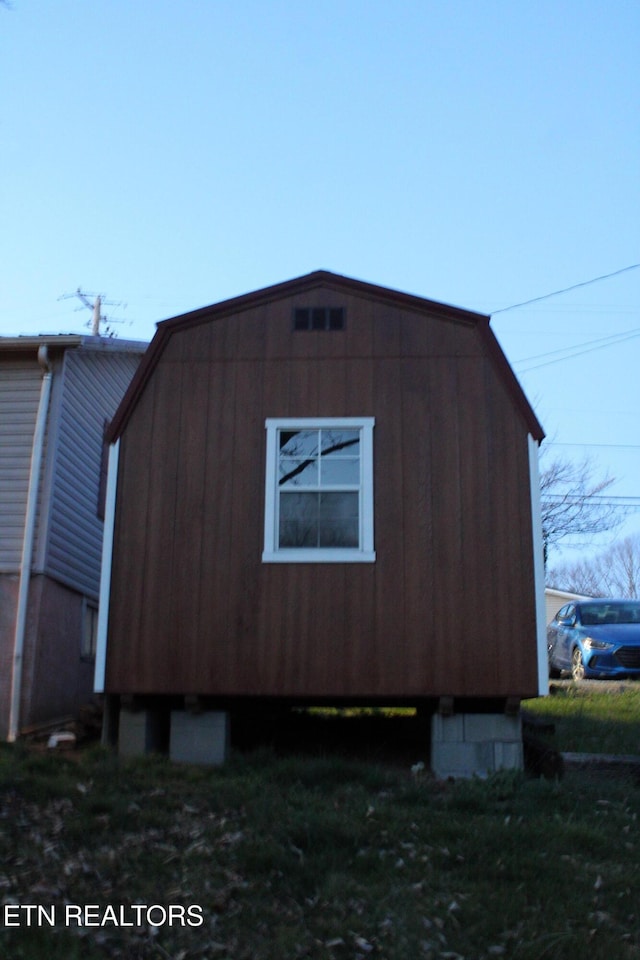 view of side of home with a gambrel roof
