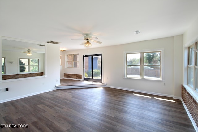 spare room featuring visible vents, dark wood-type flooring, and a ceiling fan