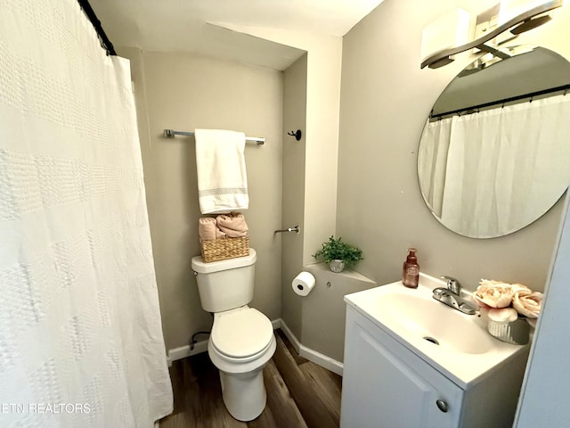 full bathroom featuring toilet, vanity, wood finished floors, and baseboards