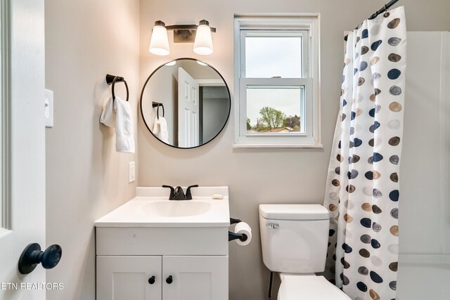bathroom featuring a shower with shower curtain, toilet, and vanity