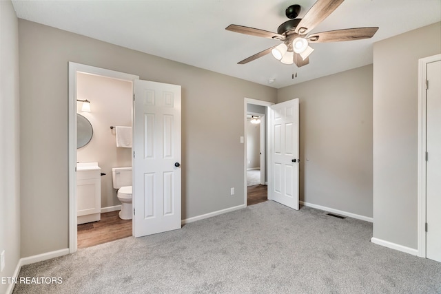 unfurnished bedroom featuring baseboards, ensuite bath, and carpet flooring