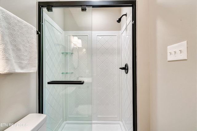 full bathroom with toilet and a shower stall
