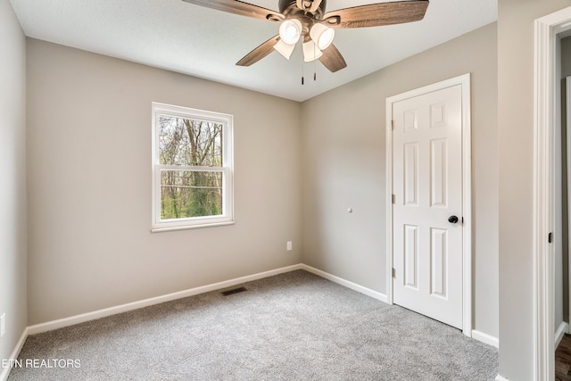 unfurnished bedroom featuring carpet floors, baseboards, ceiling fan, and visible vents