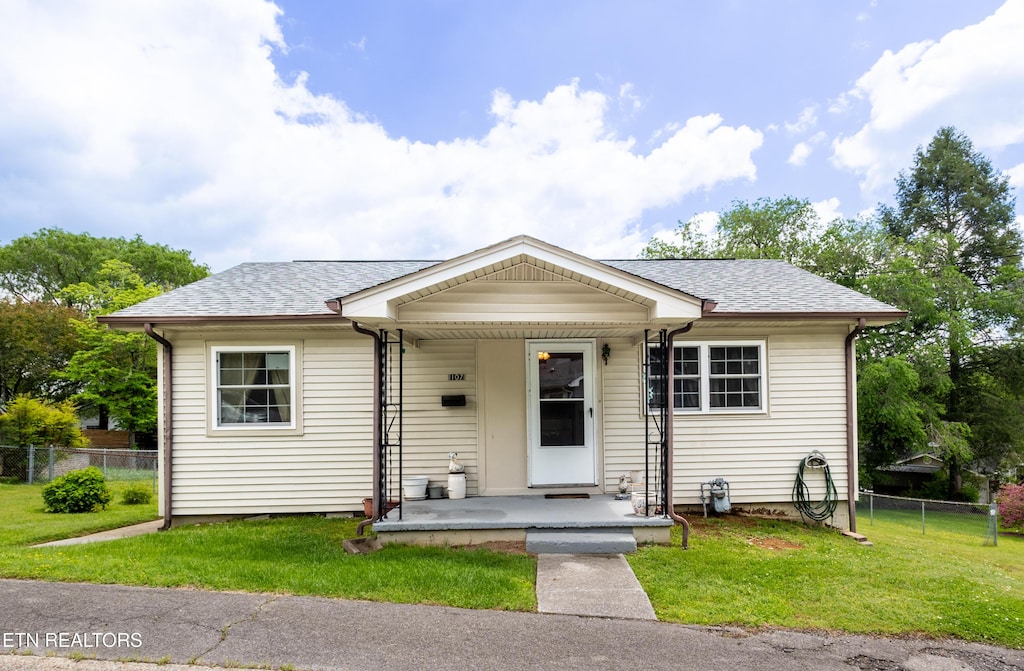 107 Upsal Rd, Oak Ridge, TN 37830 - bungalow-style house featuring fence, a shingled roof, and a front lawn