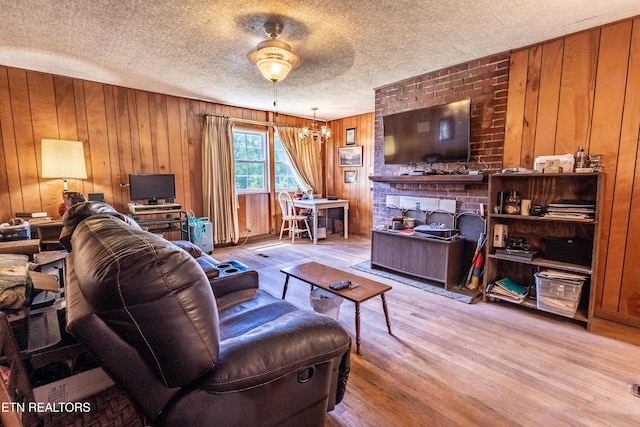 living area with a textured ceiling, wood finished floors, and wooden walls