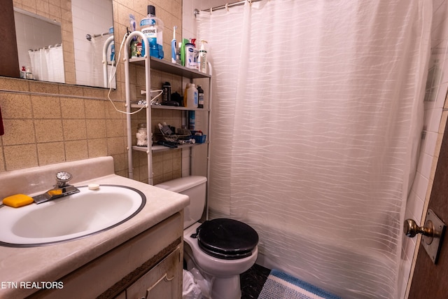 full bath with vanity, curtained shower, toilet, and tile walls